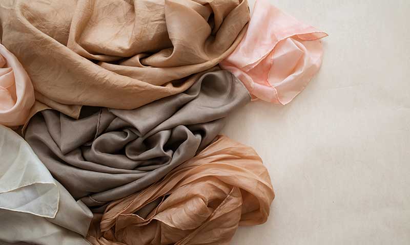 Hand dyed silk fabric in neutral grays, pinks, ivories, and browns